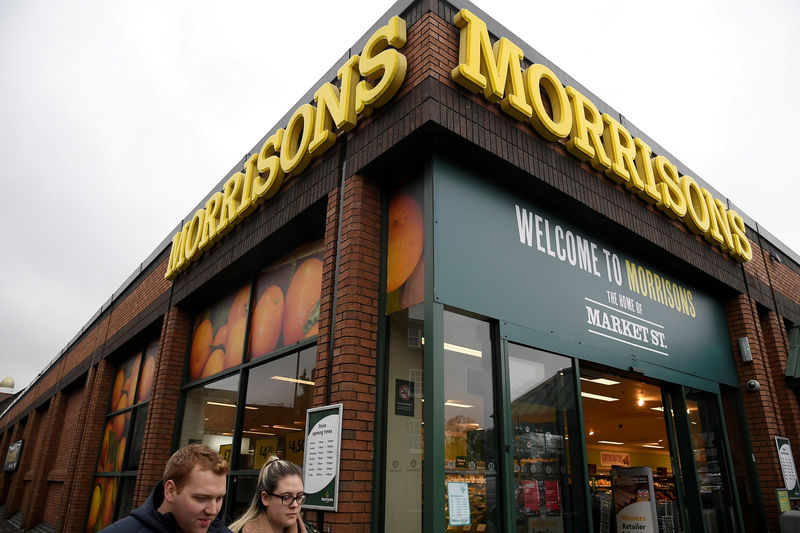 © Reuters. FILE PHOTO: Shoppers walk past a branch of the food retailer Morrisons in west London, Britain