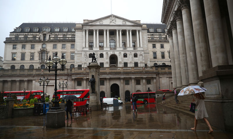 © Reuters. Pedestrians shelter under umbrellas in front of the Royal Exchange and the Bank of England, in London