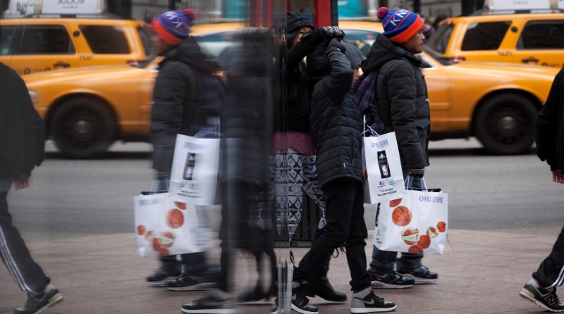 © Reuters. FILE PHOTO: People are reflected in a mirror as they shop in New York