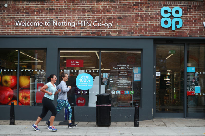 © Reuters. Women jog past a Co-op supermarket in London