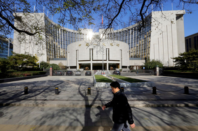 © Reuters. A man walks past the headquarters of the PBOC in Beijing