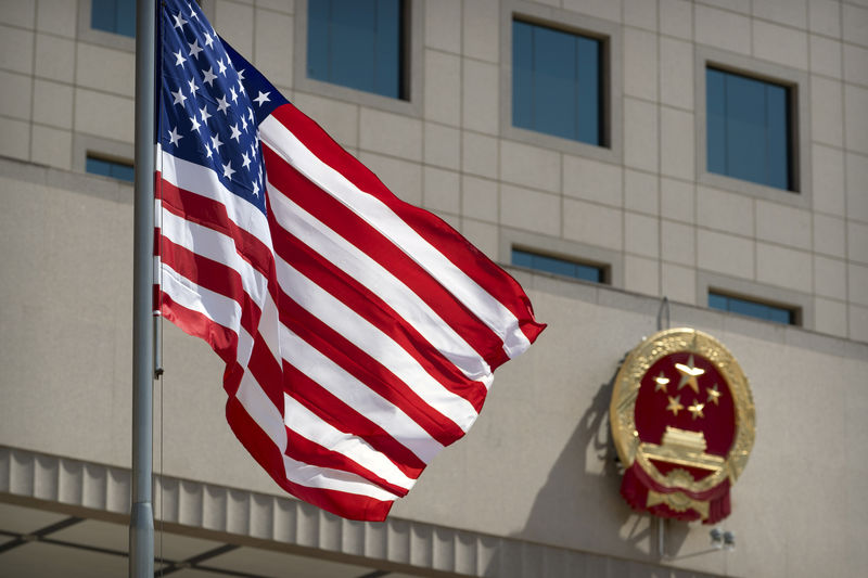 © Reuters. Американский флаг на фоне герба Китая перед церемонией приветствия министра обороны США Джима Мэттиса в Пекине