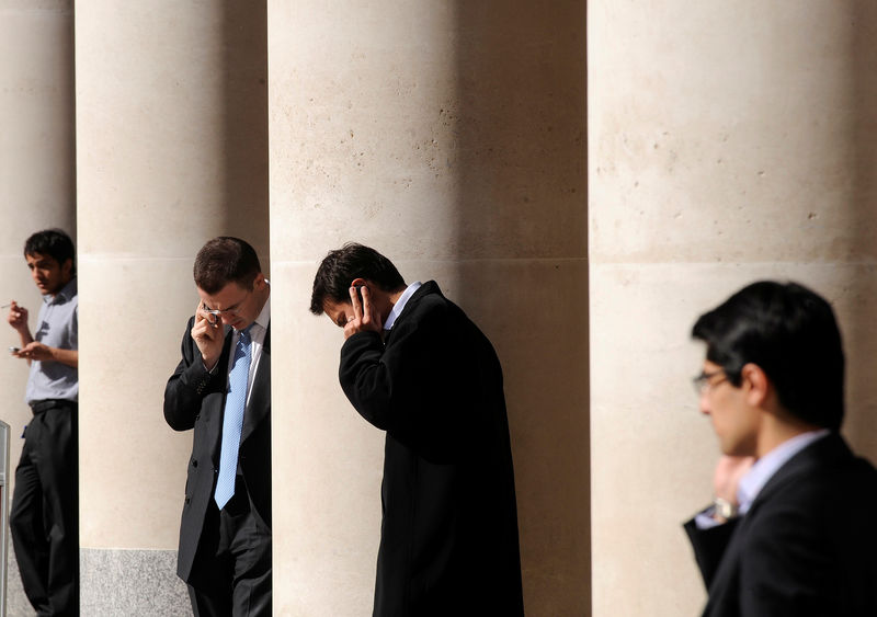 © Reuters. City workers make phone calls outside the London Stock Exchange in Paternoster Square in the City of London