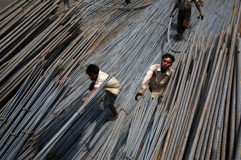 © Reuters. FILE PHOTO: Labourers load steel rods onto a truck at a steel factory on the outskirts of Jammu