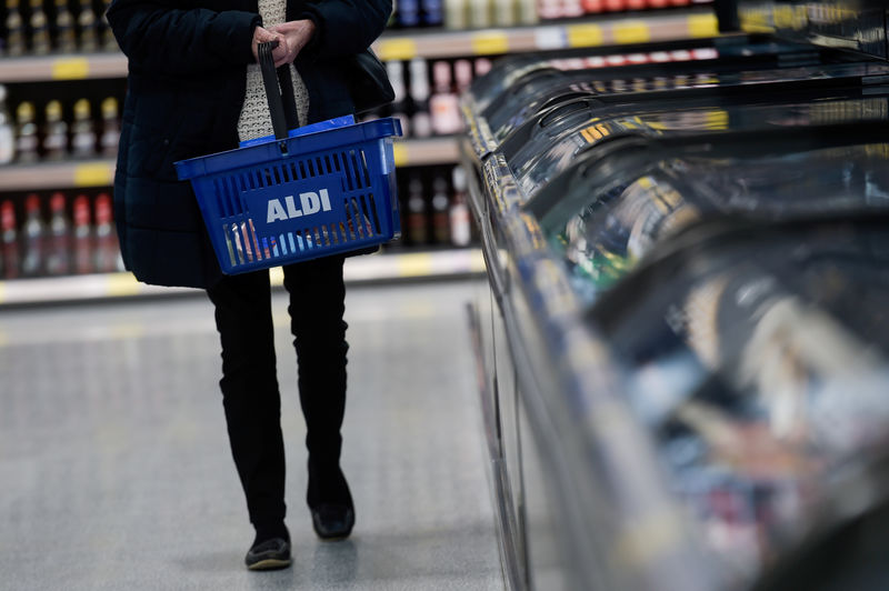 © Reuters. A woman carries a shopping basket in an Aldi store in London