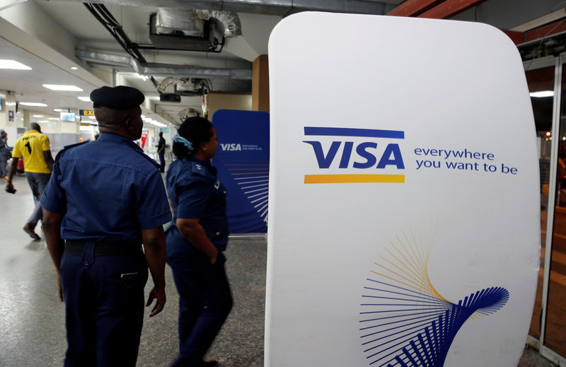 © Reuters. Security staff stand next to a Visa logo at Murtala Muhammed International Airport before the arrival of the Nigerian Women’s Bobsled Team, in Lagos