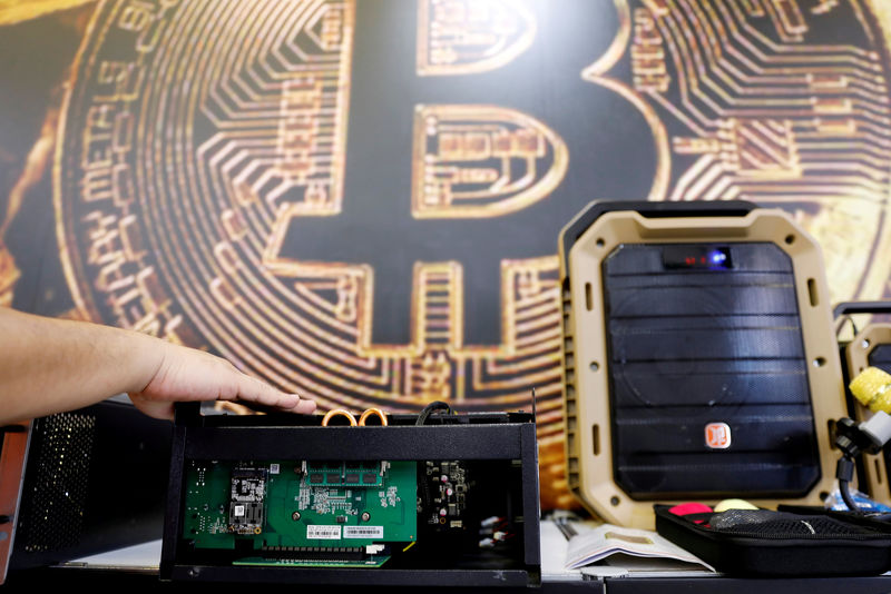 © Reuters. FILE PHOTO: A cryptocurrency mining computer is seen in front of bitcoin logo during the annual Computex computer exhibition in Taipei