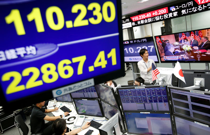 © Reuters. Employees of a foreign exchange trading company work near monitors broadcasting TV news reporting from the summit between the U.S. and North Korea in Tokyo