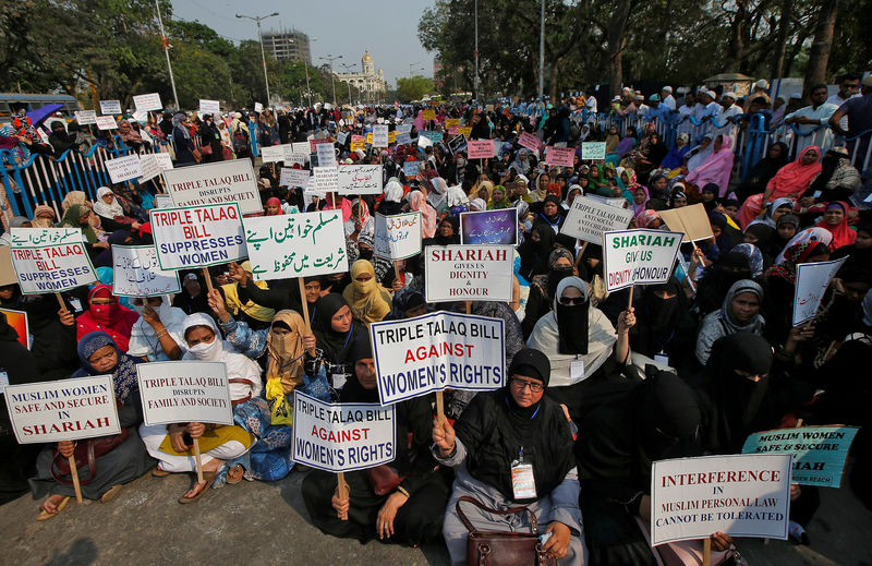 © Reuters. Muslim women hold placards during a protest rally against what they say is a bill that aims at prosecuting Muslim men who divorce their wives through the "triple talaq," or instant divorce, in Kolkata