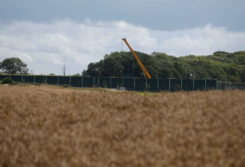 © Reuters. FILE PHOTO: A crane opertates behind barriers at Cuadrilla's Preston New Road fracking site near Blackpool