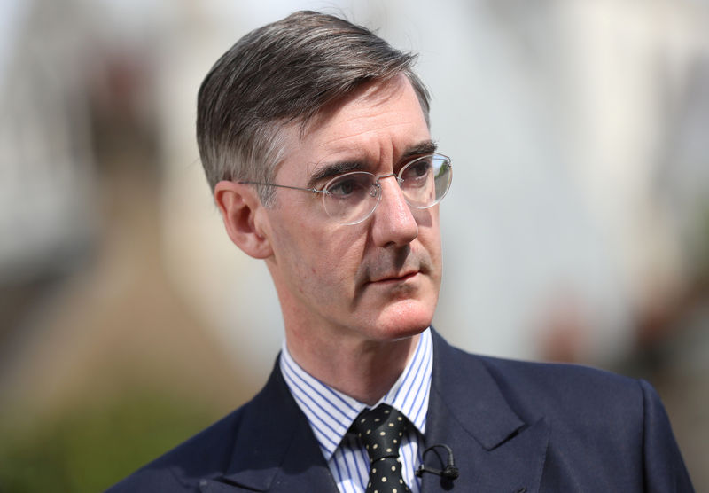 © Reuters. FILE PHOTO: Brexit campaigner Jacob Rees-Mogg talks to the media outside the Houses of Parliament after David Davis resigns from government, in London