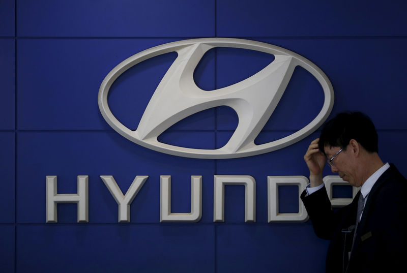 © Reuters. FILE PHOTO: A car dealer stands in front of the logo of Hyundai Motor at its dealership in Seoul
