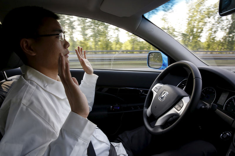 © Reuters. FILE PHOTO: Li Zengwen, a development engineer at Changan Automobile, lifts his hands off the steering wheel as the car is on self-driving mode during a test drive on a highway in Beijing