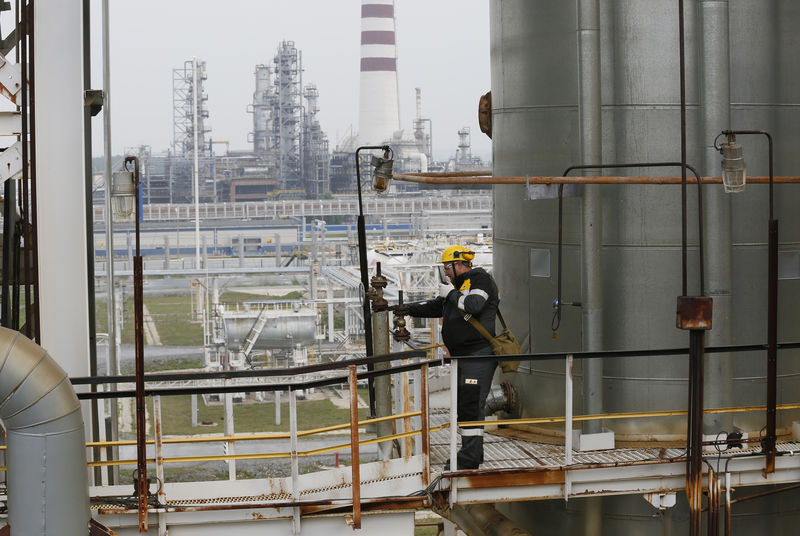 © Reuters. Работник проверяет оборудование на Ачинском нефтеперерабатывающем заводе в Красноярском крае
