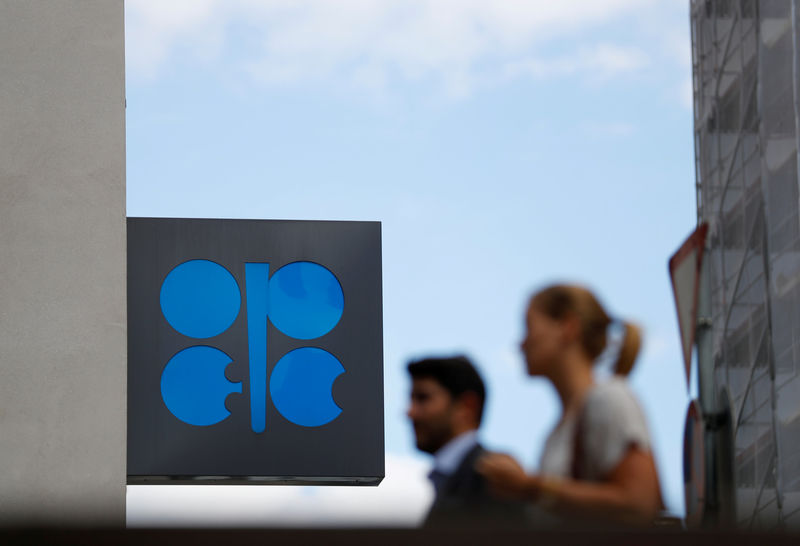 © Reuters. FILE PHOTO: Two persons pass the OPEC logo in front of OPEC's headquarters in Vienna