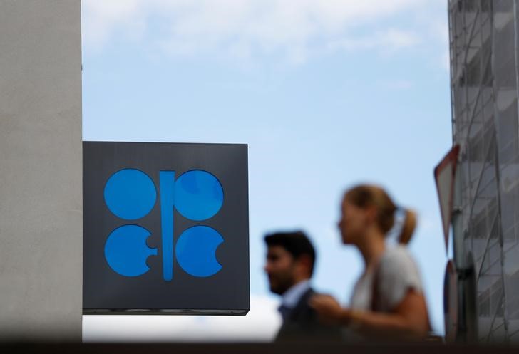 © Reuters. FILE PHOTO: Two persons pass the OPEC logo in front of OPEC's headquarters in Vienna