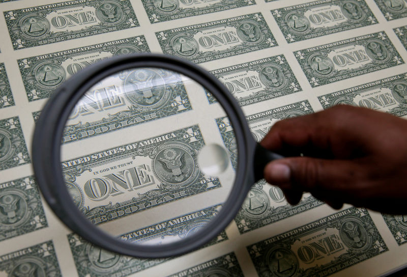 © Reuters. FILE PHOTO: United States one dollar bills are inspected under a magnifying glass during production at the Bureau of Engraving and Printing in Washington