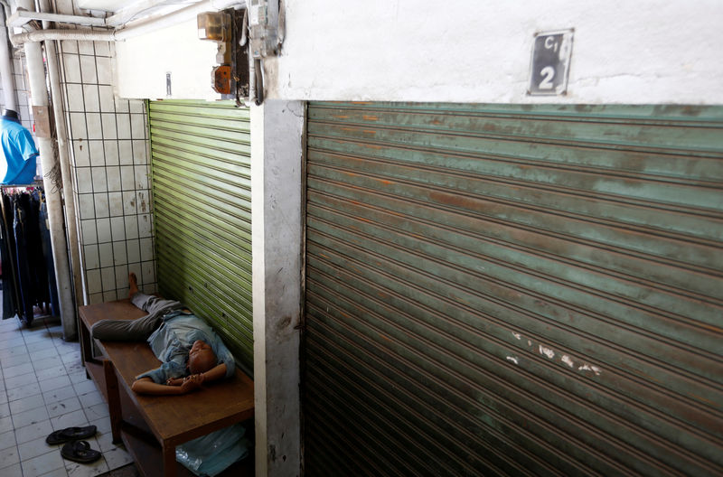 © Reuters. A man sleeps near next to a closed warehouse at Tanah Abang market in Jakarta