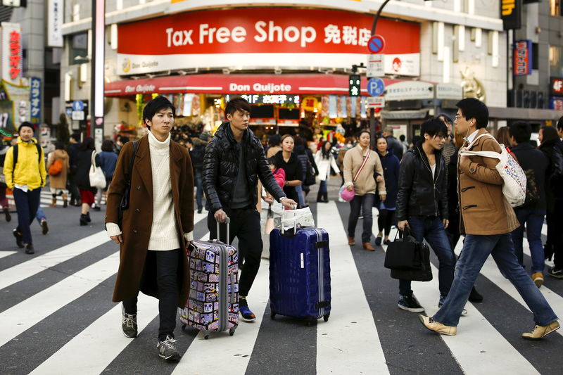 © Reuters. People cross a street outside a tax free department store popular among Chinese tourists in Tokyo