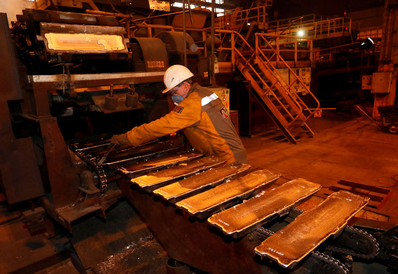 © Reuters. FILE PHOTO: A worker controls forming of aluminium ingots on a conveyor belt at the foundry shop of the Rusal Krasnoyarsk aluminium smelter in the Siberian city of Krasnoyarsk