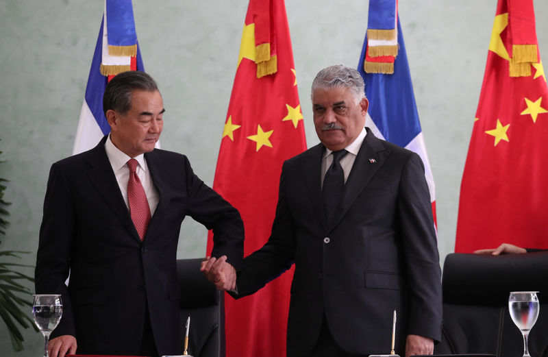 © Reuters. China's Foreign Minister Wang Yi and Dominican Republic's Chancellor Miguel Vargas shake hands after signing a bilateral agreement in Santo Domingo