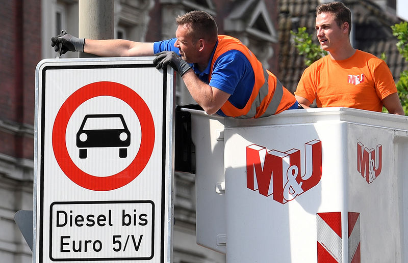 © Reuters. FILE PHOTO: Traffic signs which ban diesel cars are installed by workers at the Max-Brauer Allee in downtown Hamburg