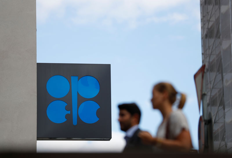 © Reuters. Two persons pass the OPEC logo in front of OPEC's headquarters in Vienna