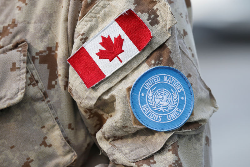 © Reuters. Patches are seen on a member of Canadian Forces before departing for a U.N. peacekeeping mission in Mali, at CFB Trenton