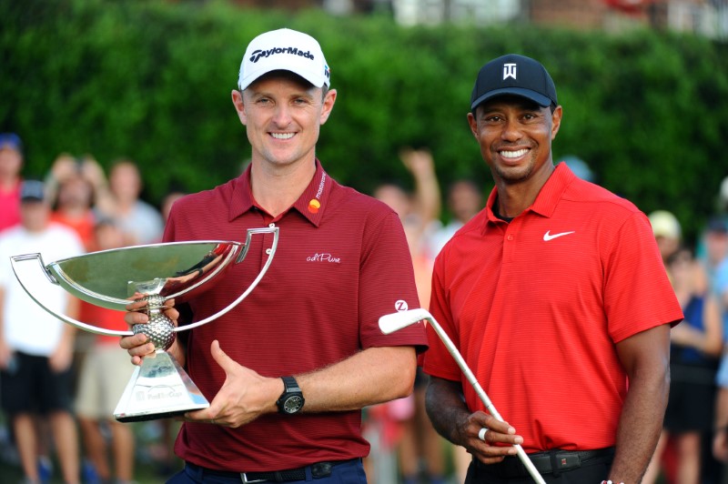 © Reuters. Justin Rose sostiene la Copa FedEx y Tiger Woods (derecha) sostiene la Calamity Jane, una réplica del putter de Bobby Jones después de ganar el torneo de golf Tour Championship en East Lake Golf Club Atlanta, GA, Estados Unidos