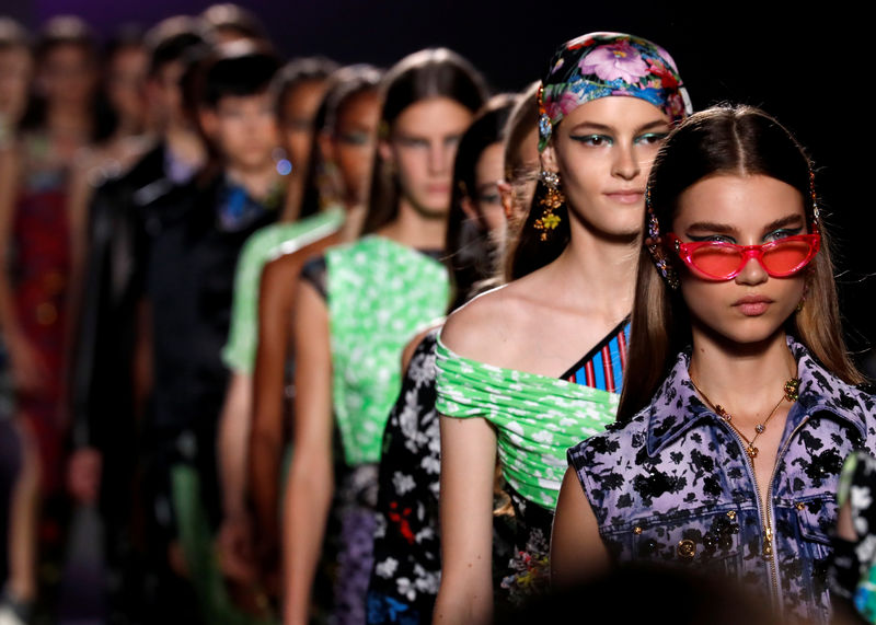 © Reuters. Modelle indossano abiti Versace ad una sfilata a Milano
