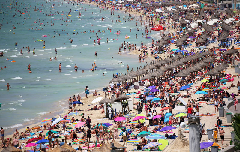 © Reuters. Tourists sunbathe in El Arenal beach in the island of Mallorca