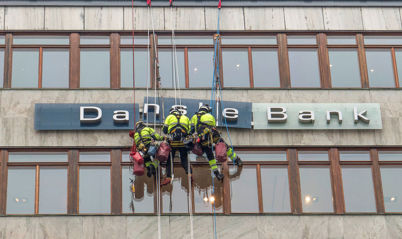 © Reuters. Workers are seen next to a "Danske Banks" sign in central Stockholm