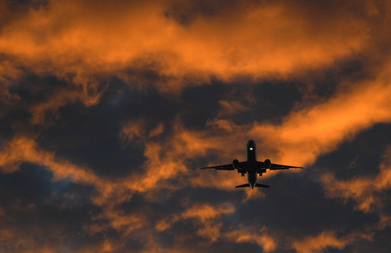 © Reuters. FILE PHOTO - A passenger plane flies towards Heathrow airport at dawn in London, Britain