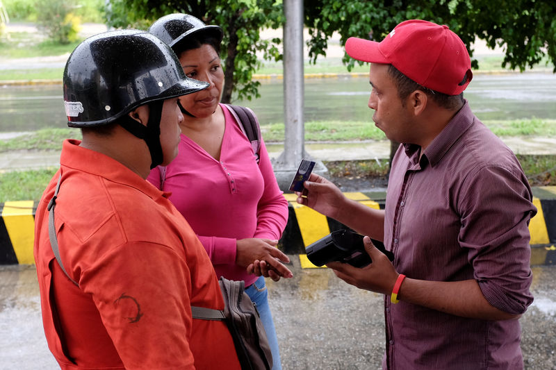 © Reuters. Worker explains Venezuela's new digital fuel payment system to motorists at a gas station of PDVSA in Caracas