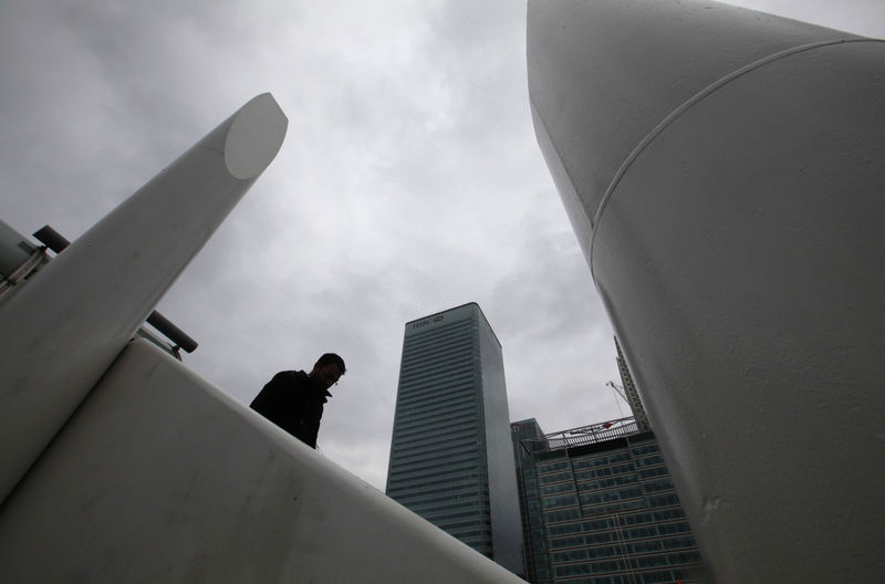 © Reuters. Un hombre camina cerca de Canary Wharf, el distrito financiero de Londres