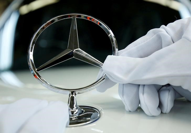 © Reuters. FILE PHOTO: An employee of German car manufacturer Mercedes Benz installs the brand's characteristic star on a Mercedes S-Class (S-Klasse) at a production line at the Mercedes Benz factory in Sindelfingen