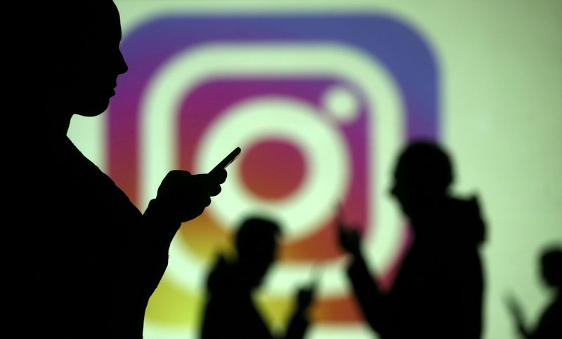 © Reuters. Силуэты людей на фоне логотипа Instagram