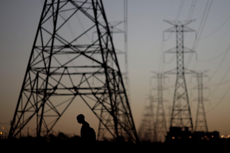 © Reuters. Homem passa por torres de energia
