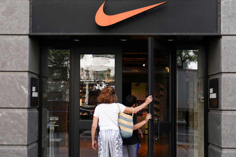© Reuters. People walk into a Nike store in New York City,
