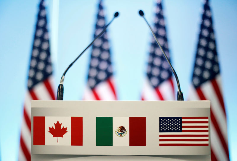 © Reuters. The flags of Canada, Mexico and the U.S. are seen on a lectern before a joint news conference on the closing of the seventh round of NAFTA talks in Mexico City