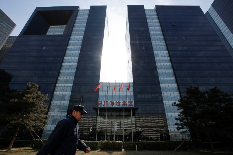 © Reuters. FILE PHOTO: A man walks past the office of Anbang Insurance Group in Beijing