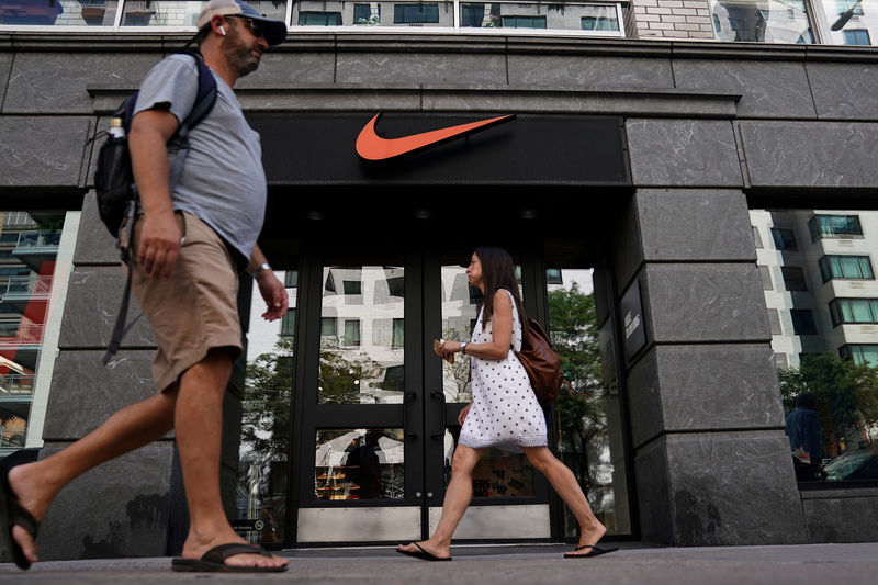 © Reuters. FILE PHOTO: People walk past a Nike store in New York City,