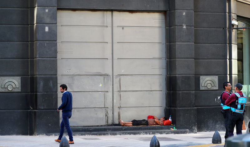 © Reuters. A man sleeps outside a bank in Buenos Aires' financial district