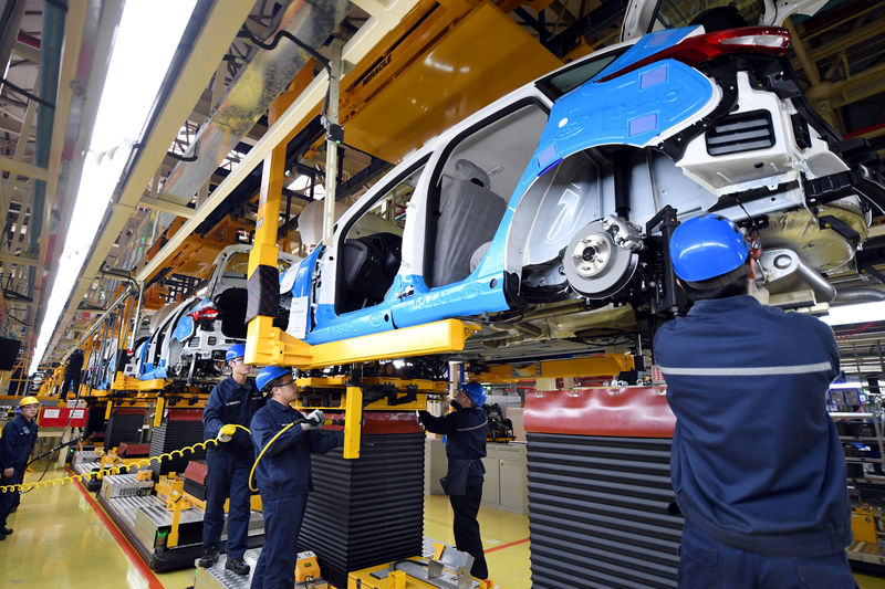 © Reuters. FILE PHOTO: Workers assemble vehicles at a plant of Changan Ford in Harbin