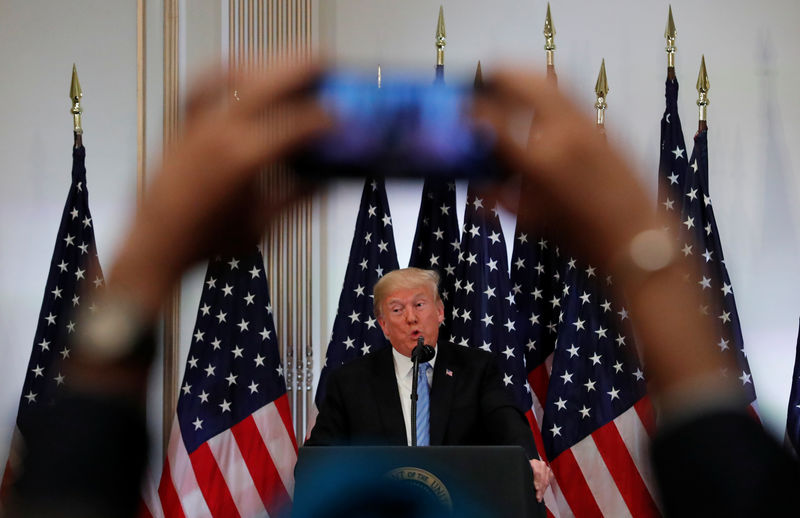 © Reuters. Foto del miércoles de un periodista usando su teléfono celular para fotografiar al presidente de EEUU, Donald Trump, en una rueda de prensa en Nueva York