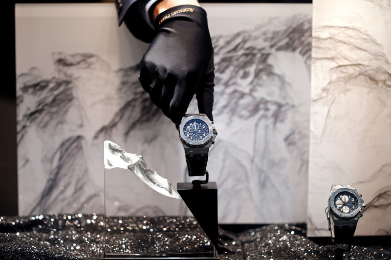 © Reuters. FILE PHOTO: A salesman displays a high-end watch at an Audemars Piguet boutique in Manama