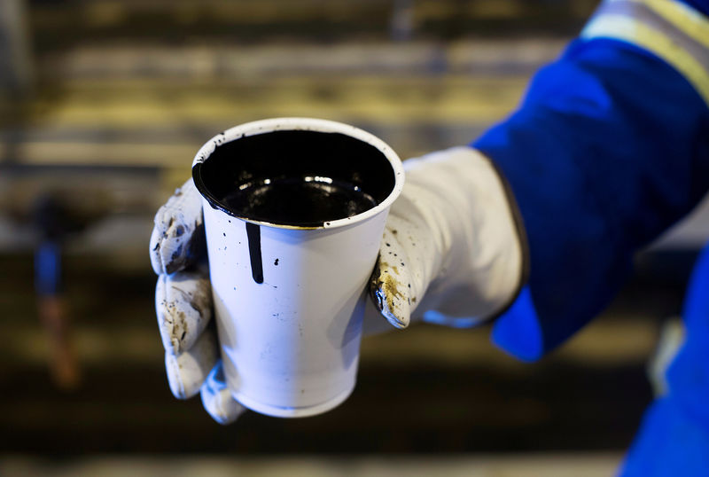 © Reuters. FILE PHOTO: A worker holds a cup of heavy oil south of Fort McMurray