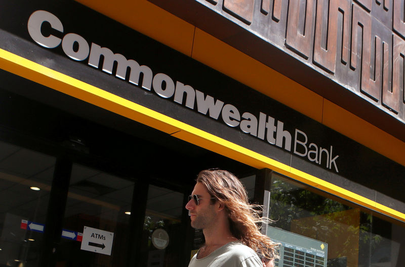 © Reuters. FILE PHOTO: A man uses his mobile phone as he leaves the Commonwealth Bank of Australia building in central Sydney