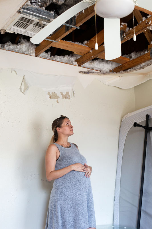 © Reuters. Jennifer Maher, pregnant in her third trimester, looks over damage to her home post-Hurricane Florence at Marine Corps Base Camp Lejeune