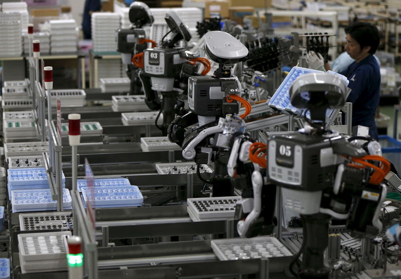 © Reuters. Humanoid robots work side by side with employees in the assembly line at a factory of Glory Ltd., a manufacturer of automatic change dispensers, in Kazo, north of Tokyo